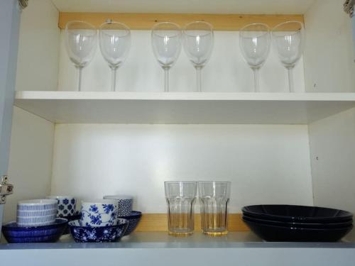 a shelf with wine glasses and bowls on it at Aegina Port Apt 2-Διαμέρισμα στο λιμάνι της Αίγινας 2 in Aegina Town