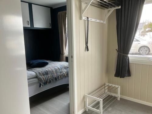 ein kleines Schlafzimmer mit einem Bett und einem Fenster in der Unterkunft Koselig, nyoppusset leilighet in Gjøvik
