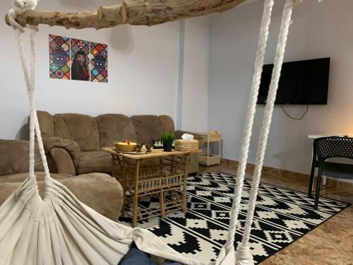 uma sala de estar com um sofá e um baloiço em Villa in a compound with a rooftop in sheikh zayed em Sheikh Zayed
