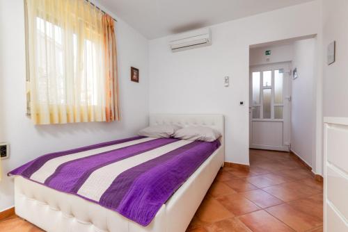 a bedroom with a bed with a purple blanket at Apartments Manuela in Pula