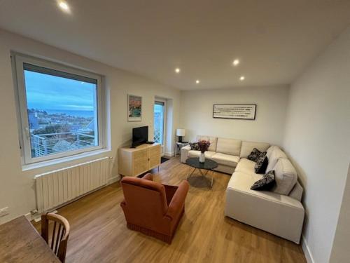 un salon avec un canapé et une fenêtre dans l'établissement LES BORDS DE MER, à Saint-Pol-de-Léon