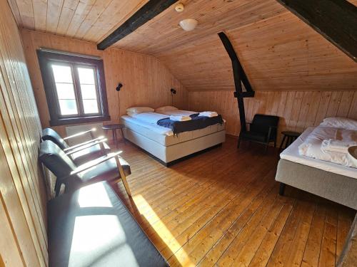 una camera con due letti e una sedia in una cabina di Salteriet a Å