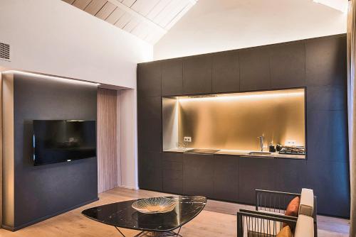 a living room with a glass table and a kitchen at HomeSuiteHome Córdoba in Córdoba