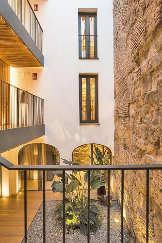 a house with a stone wall and black railings at VillaMora Alfaros 35 FREE PARKING in Córdoba