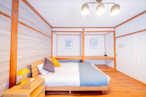a bedroom with a bed and a night stand and a table at Furano Powder Chalet in Furano
