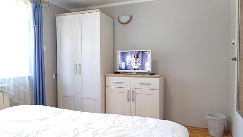 1 dormitorio con 1 cama y TV en un armario en Matylda House, en Cracovia