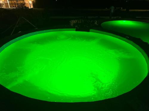 a green bath tub filled with green water at night at Eco Cabañas Montana in Santa Helena