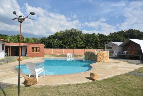 a swimming pool with a chair and a light pole at Eco Cabañas Montana in Santa Helena