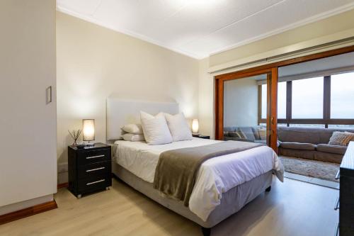 een slaapkamer met een groot bed en een bank bij A luxurious and modern apartment in Midrand