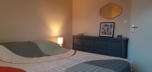 a bedroom with a bed and a dresser at Appartement avec grand balcon sud et parking privé in Saint-Brieuc