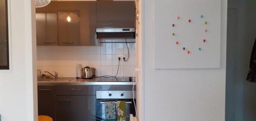 une cuisine avec une cuisinière et un évier dans l'établissement Appartement avec grand balcon sud et parking privé, à Saint-Brieuc