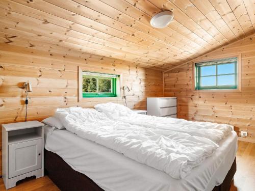 um quarto com uma cama grande num quarto de madeira em Holiday home Tjørhom II em Tjørhom