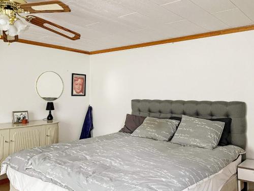 een slaapkamer met een bed en een plafondventilator bij Holiday home VÄDDÖ III in Väddö