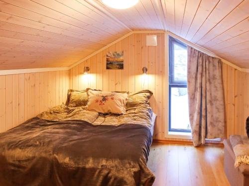 een slaapkamer met een bed in een kamer met een raam bij Holiday home Risør in Risør
