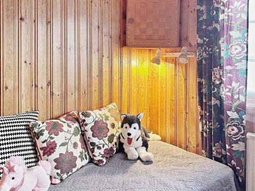 a stuffed dog sitting on a bed with pillows at Holiday home GRøDINGE in Vårsta