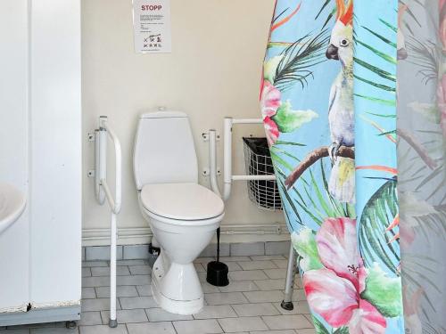a bathroom with a toilet and a shower curtain at Holiday home GRøDINGE in Vårsta