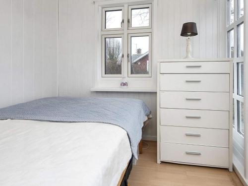 una camera con un comò bianco e un letto di Holiday home Grenaa XXXII a Grenå