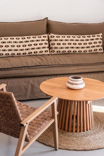 a coffee table and a chair in front of a couch at Remvi apartments in Agios Nikolaos