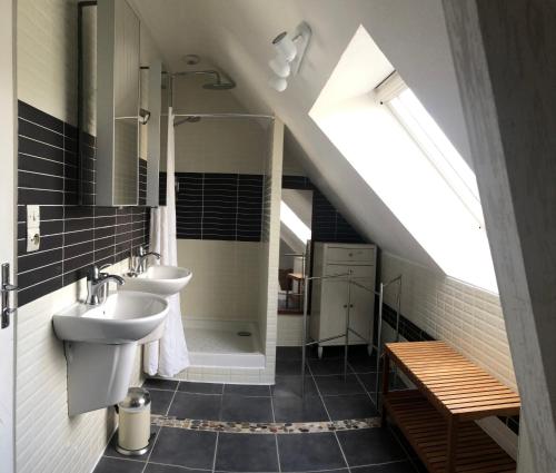 une salle de bains mansardée avec deux lavabos et une douche. dans l'établissement Chez Alix et Christophe, à Trélazé