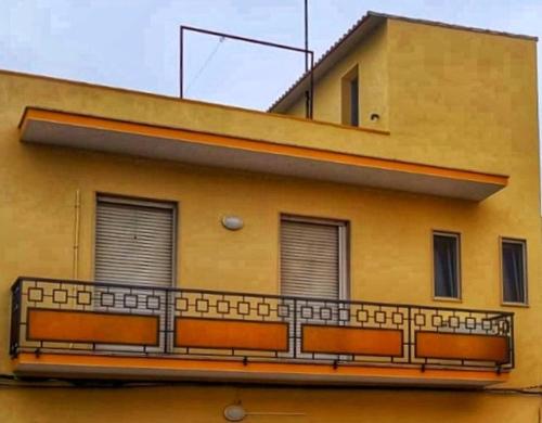 balcone sul lato di un edificio con finestre di Appartamento Ruffano a Ruffano