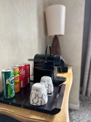 a table with cans of coke and a coffee maker at Logis Hôtels Château de La Barge in Chaintré