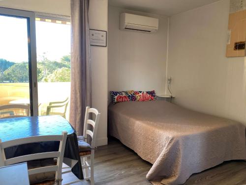 une chambre avec un lit, une table et une fenêtre dans l'établissement Studio lumineux avec balcon, wifi, clim, proximité parc - FR-1-553-227, à Balaruc-les-Bains