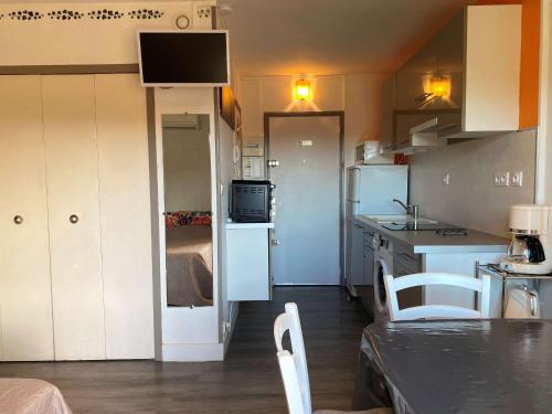 Il comprend une petite cuisine avec des placards blancs et un réfrigérateur. dans l'établissement Studio lumineux avec balcon, wifi, clim, proximité parc - FR-1-553-227, à Balaruc-les-Bains