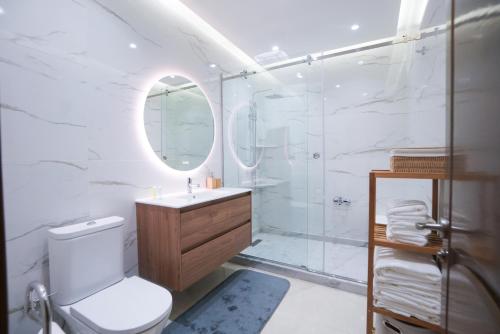 un bagno con doccia, WC e lavandino di Appartement Cosy à Malabata Plage - Bord de mer et Gare TGV 3' à pied, Tanger City Mall à 2' à pied - Parking, WIFI, IPTV, AC a Tangeri