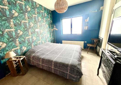 1 dormitorio con cama y pared azul en Chambre tropicale privée, en Liévin