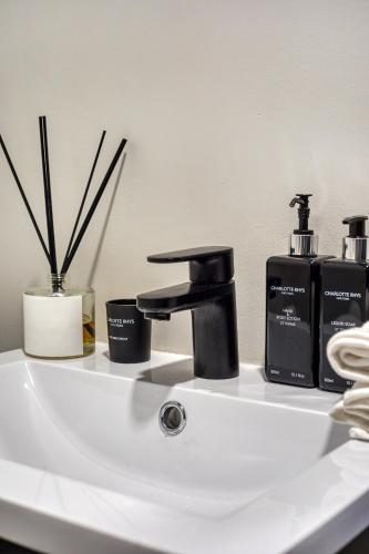 a bathroom sink with two bottles of soap at Luxury Mountain View Aparthotel at The Tokyo- 12th Floor No Loadshedding in Cape Town