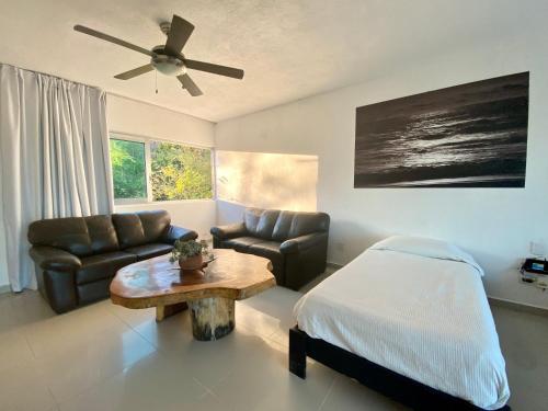 a living room with a bed and a couch and a table at Vistas a las Montañas y al Mar I Condominio Las Calandrias I Alberca I Wi-Fi in Ixtapa