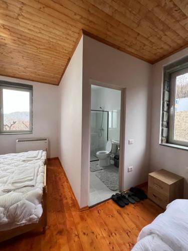 a bedroom with two beds and a bathroom at Xhaferri Guesthouse in Çorovodë