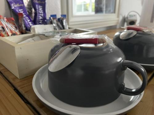 a black tea kettle on a plate on a table at The Kings Arms Inn in Yeovil