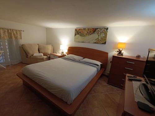 a bedroom with a bed and a couch and a chair at Napoleon in Pozzuoli