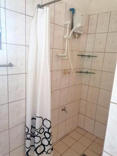 a shower with a white shower curtain in a bathroom at Sulu Sunset Beach Resort in Nauhang