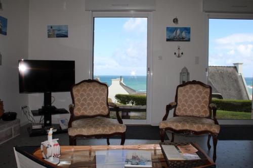 - un salon avec deux chaises, une table et une télévision dans l'établissement 707 -Maison de charme au Domaine privée De Lanruen, à Erquy