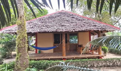a small house with a hammock in front of it at Sulu Sunset Beach Resort in Nauhang
