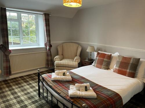 a bedroom with a bed and a chair and a window at The Kings Arms Inn in Yeovil