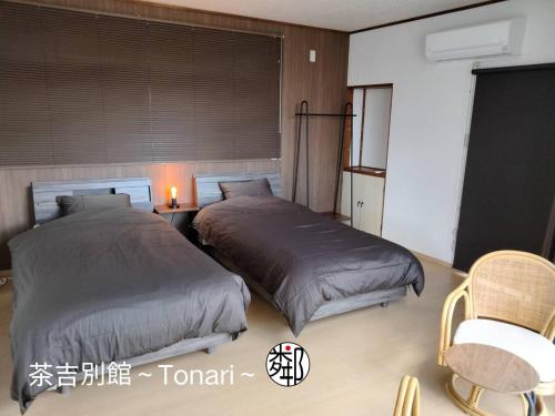 two beds sitting next to each other in a bedroom at Guesthouse Sakichi in Beppu