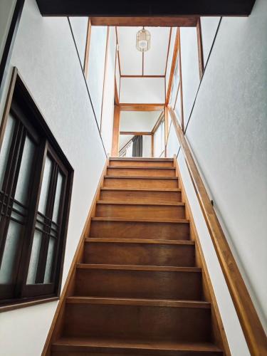 a staircase leading up to a building with a window at Guesthouse Sakichi in Beppu