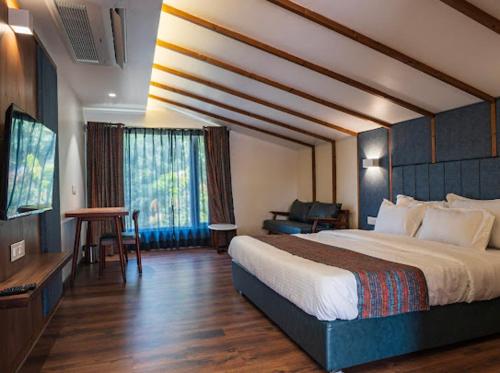 pokój hotelowy z łóżkiem i telewizorem w obiekcie Casa Oro w mieście Ujjain