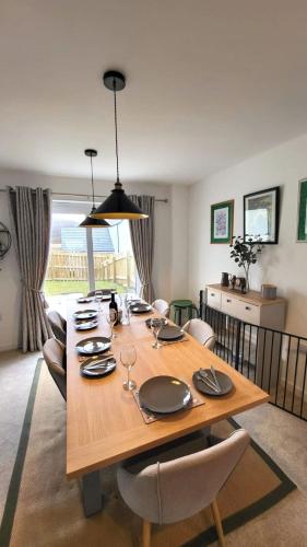 a dining room with a wooden table and chairs at Insch House in Kincraig