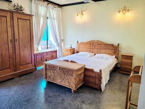 Un dormitorio con una gran cama de madera y una ventana en VILLA COLOMBO7 5BR HOLIDAY HOME UP to 10 Guests, en Colombo