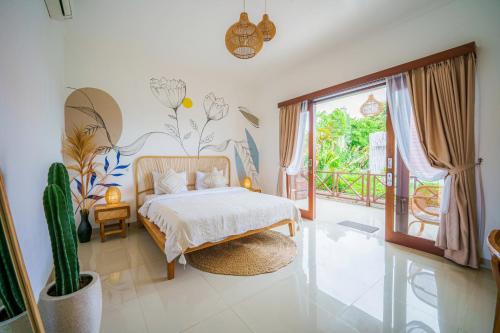 1 dormitorio con cama y cactus en Shortcut Breeze Guest House, en Canggu