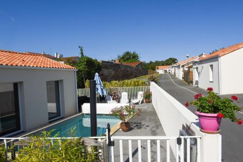 a villa with a swimming pool and a white fence at Résidence Les Océanes in Les Sables-dʼOlonne
