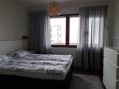 a small bedroom with a bed and a window at Elice Apartment in Rovaniemi