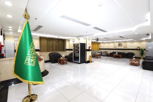 a large lobby with a green umbrella in the middle at فندق ملتقي الإيمان للضيافة السياحي in Makkah