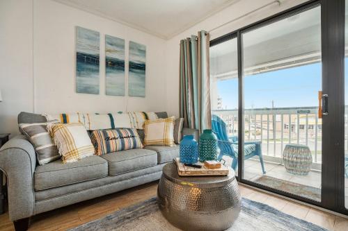 a living room with a couch and a large window at Tipsea on the seawall in Galveston