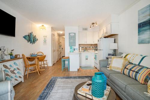 a living room with a couch and a kitchen at Tipsea on the seawall in Galveston