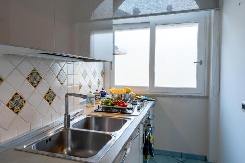 een keuken met een wastafel en een raam bij Maiori Apartment by Marcel in Maiori